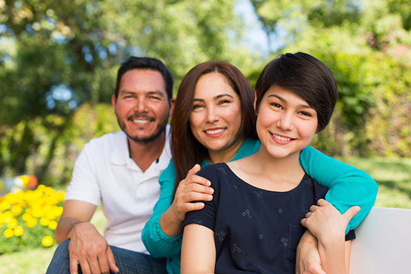Portrait of happy family smiling together in a park